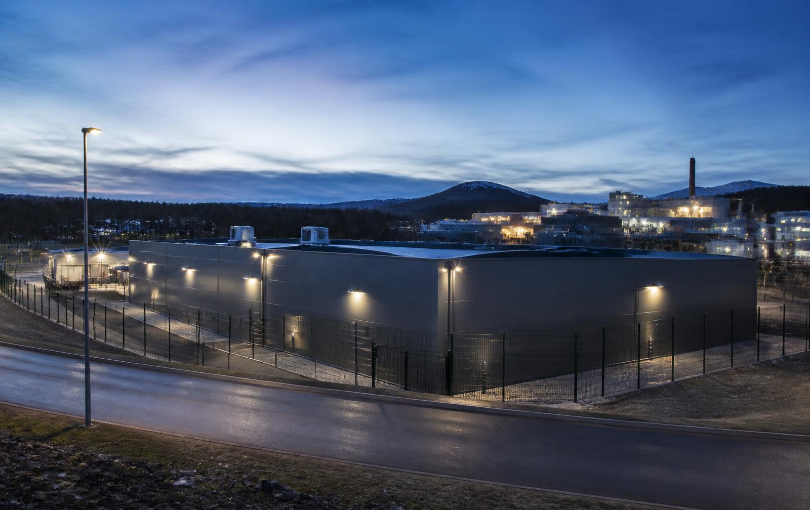Secure operational facility with perimeter fencing at dusk